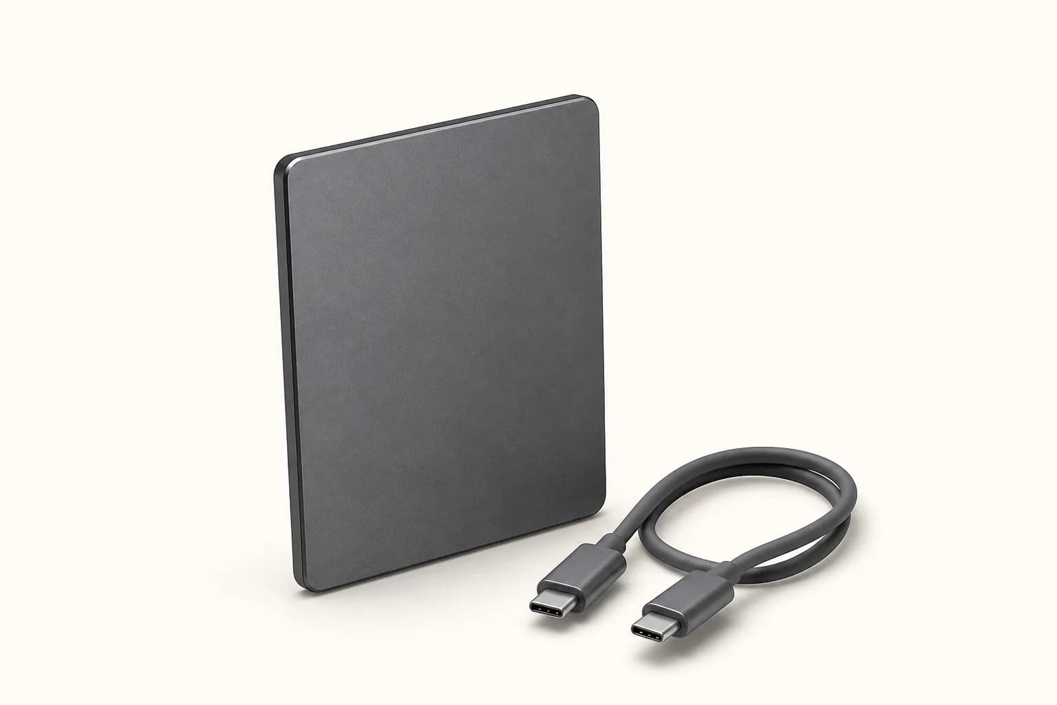 Small dark rectangular portable solid-state drive with a USB-C cable.